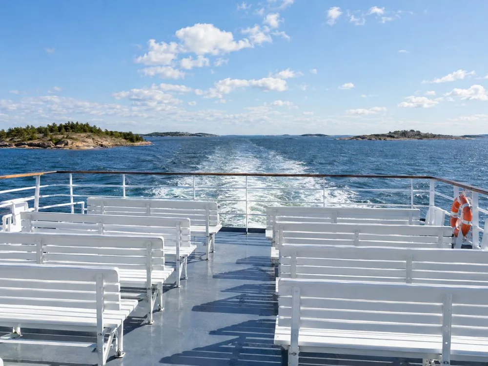 Passengers on the open sundeck of a Helsinki archipelago sightseeing boat